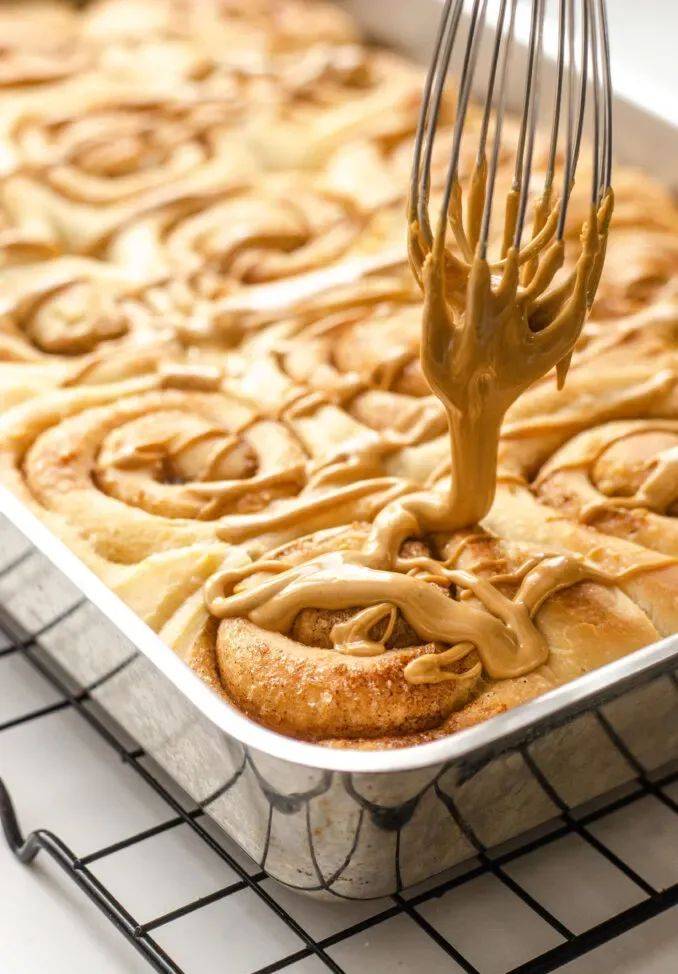 Drizzling the icing over the cooled cinnamon rolls. ' title='Cinnamon Roll Recipe Without Milk
