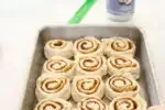 Placing the sliced cinnamon buns into the prepared pan.' title='Cinnamon Roll Recipe Without Milk