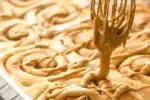Drizzling the icing over the cooled cinnamon rolls.' title='Cinnamon Roll Recipe Without Milk