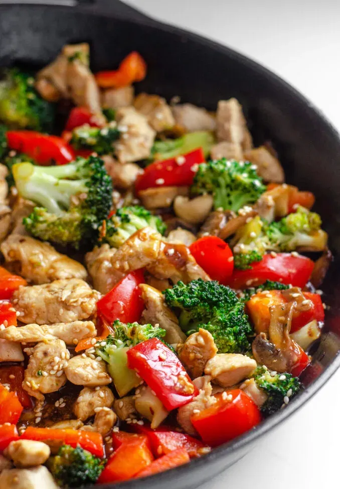 A large cast iron skillet filled with healthy chicken stir fry with loads of veggies.' title='Healthy Chicken Stir Fry Recipe