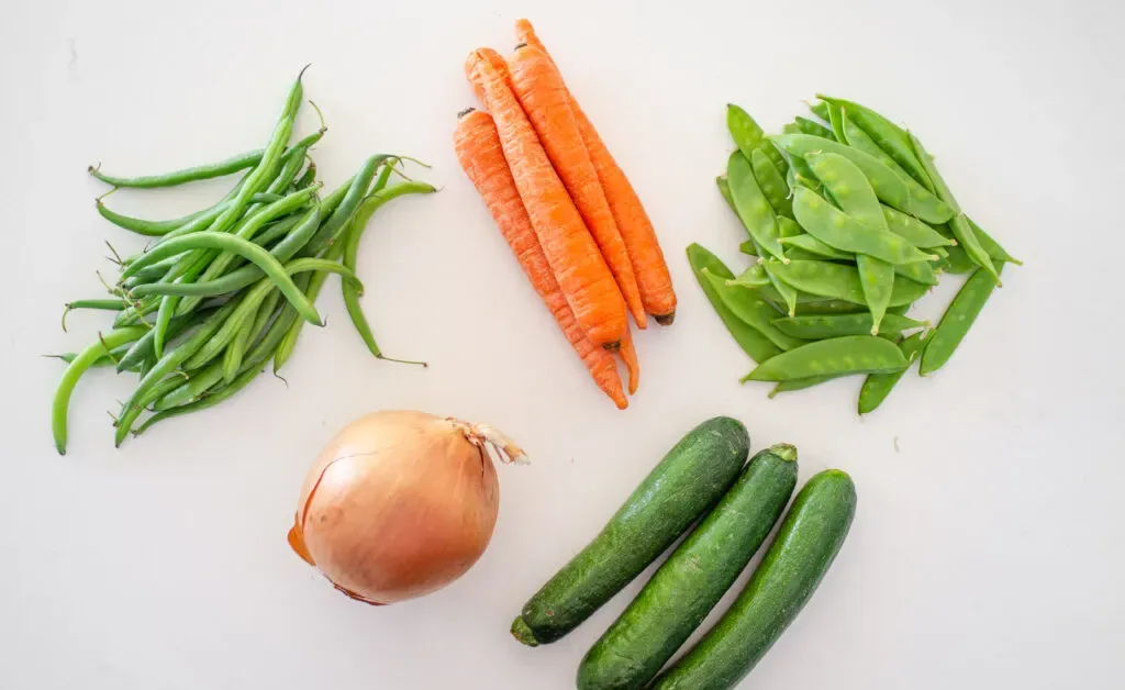 Different kinds of vegetables that you can use to make a stir-fry laid out on a white counter. ' title='Healthy Chicken Stir Fry Recipe
