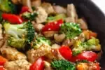 A large cast iron skillet filled with healthy chicken stir fry with loads of veggies.' title='Healthy Chicken Stir Fry Recipe
