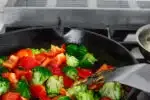 Adding the red bell peppers to the stir fry.' title='Healthy Chicken Stir Fry Recipe