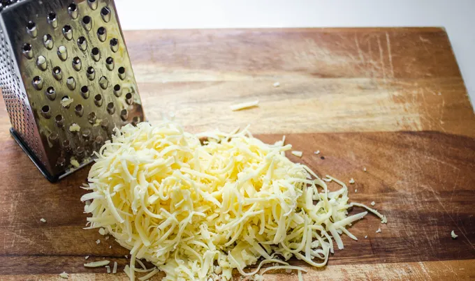 Grating the cheese by hand.' title='BLT Bowtie Pasta Salad