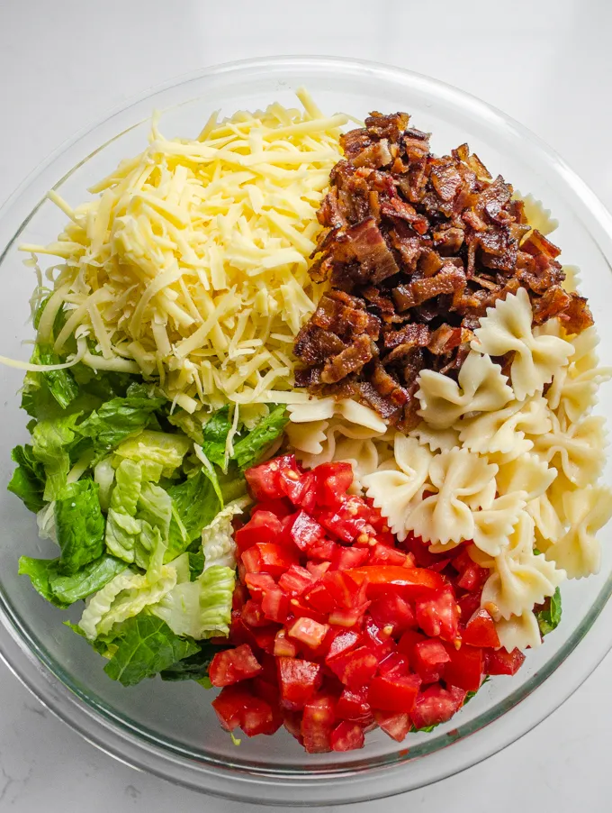 All of the prepped ingredients in the bowl.' title='BLT Bowtie Pasta Salad