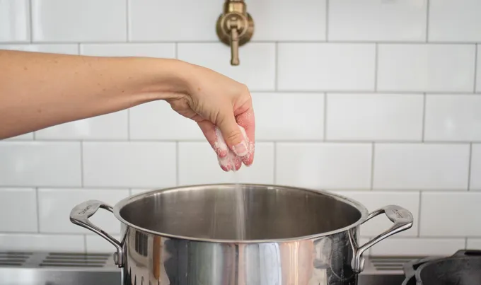 Adding salt to the pot of water.' title='BLT Bowtie Pasta Salad