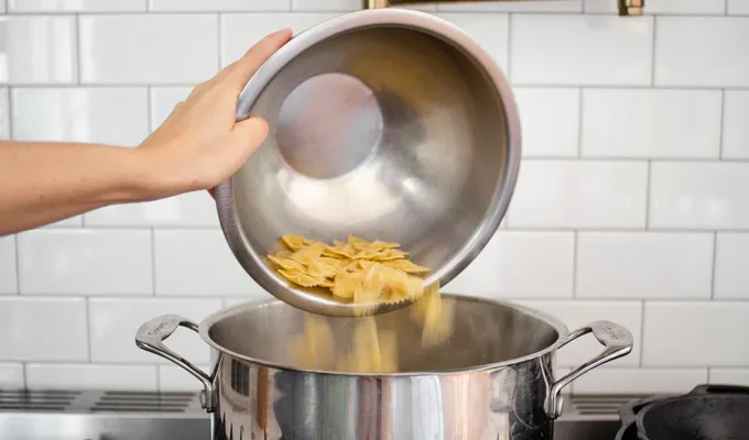 Adding the pasta to the boiling water.' title='BLT Bowtie Pasta Salad