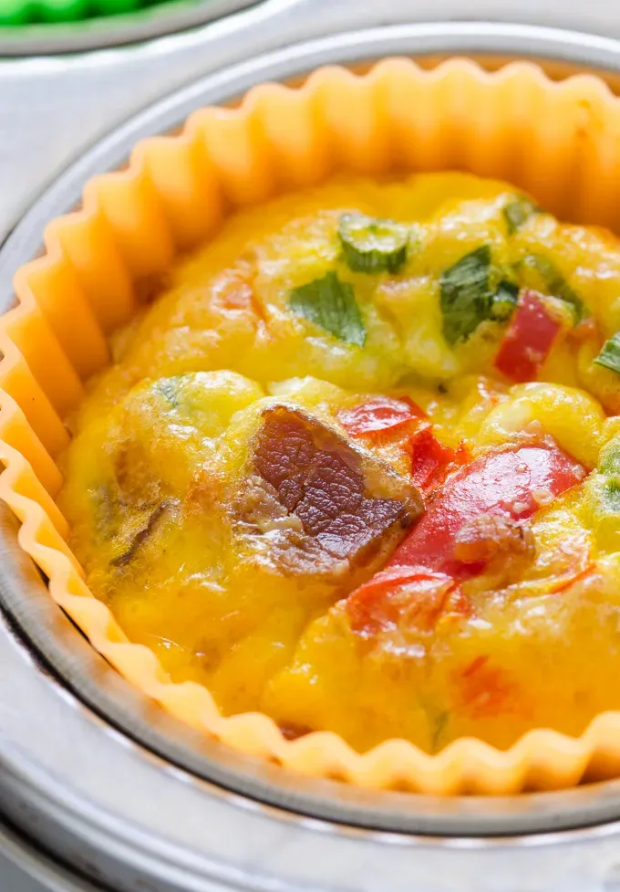 Close up shot of a baked egg muffin cup.' title='Egg Muffin Cups with Cottage Cheese Bacon and Peppers