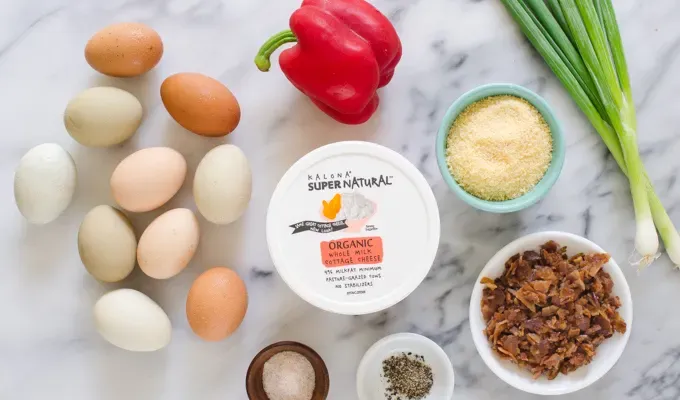 Ingredients for egg muffins from above on a marble surface.' title='Egg Muffin Cups with Cottage Cheese Bacon and Peppers