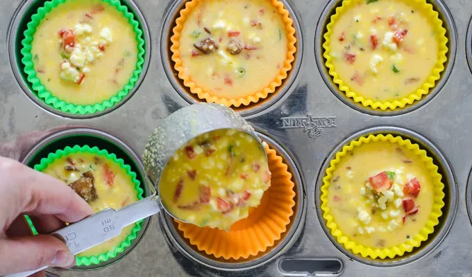 Pouring the batter into the muffin cups.' title='Egg Muffin Cups with Cottage Cheese Bacon and Peppers