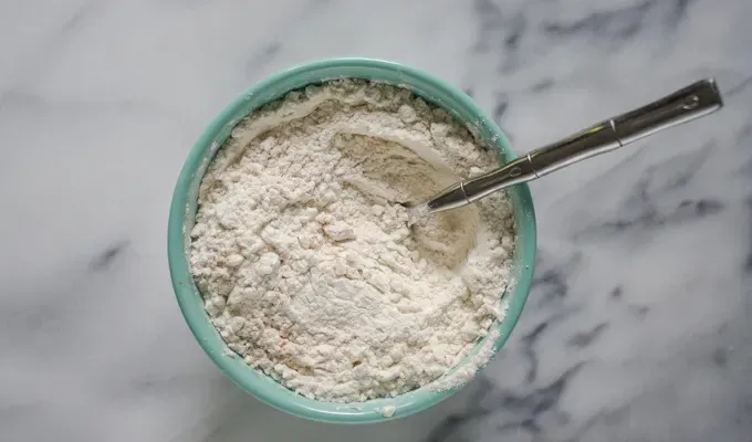 Dry ingredients for the banana bread in a bowl on a marble surface.' title='Sourdough Banana Bread