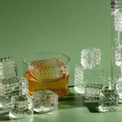 Stacks of perfectly clear ice in rocks glass and Collins glass, with shapes embedded