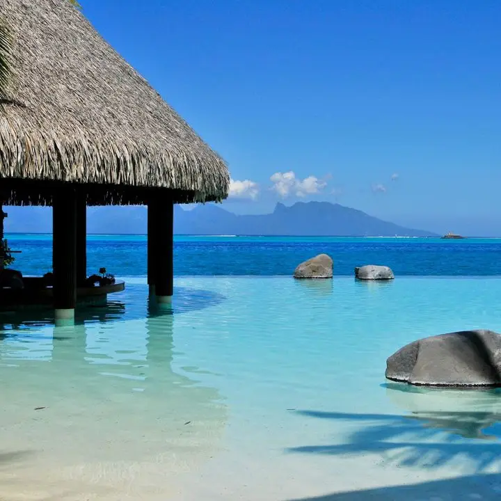 InterContinental Tahiti swim-up bar. Expanses blue water forever and a thatched bar-hut in front