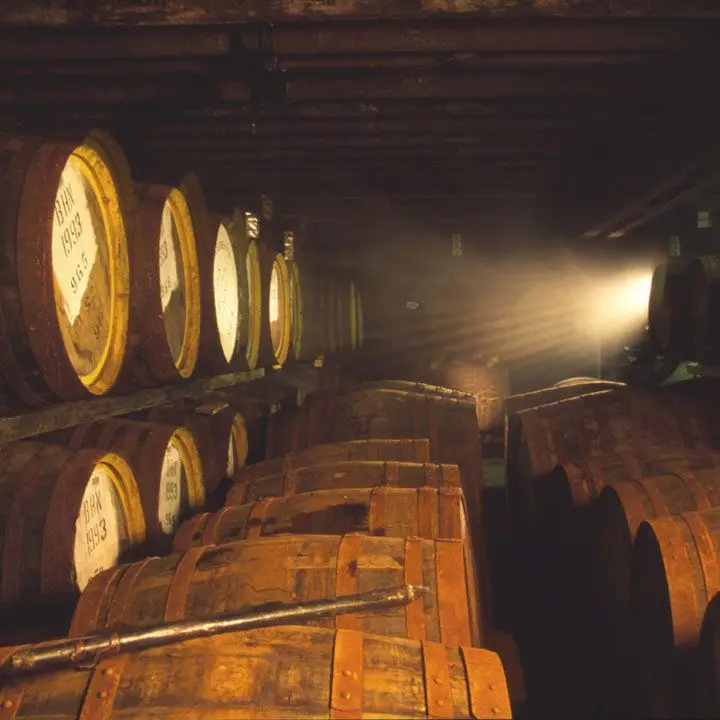 Bunnahabhain Distillery and a barrel room with slight light and oodles of aging barrels