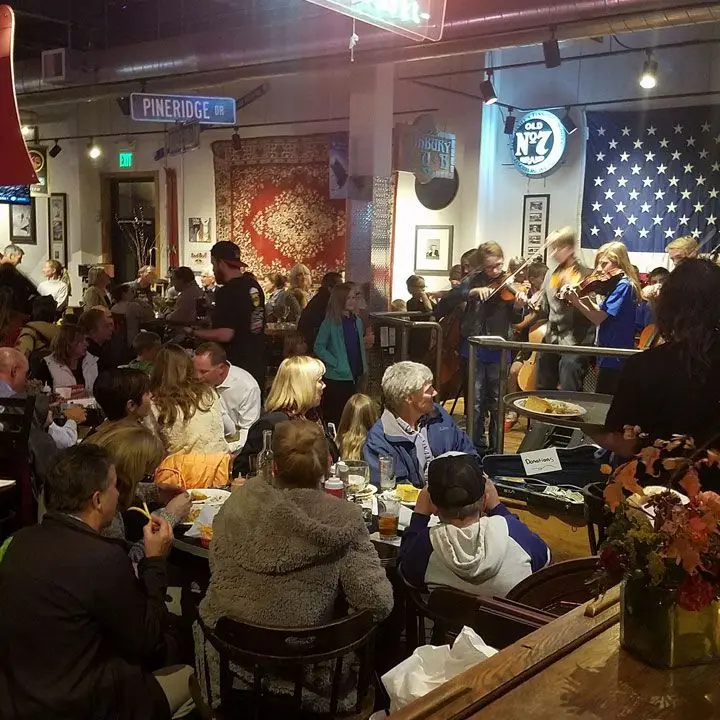 O’Shucks Utah. A four-piece band plays fiddles and guests look on as they dine