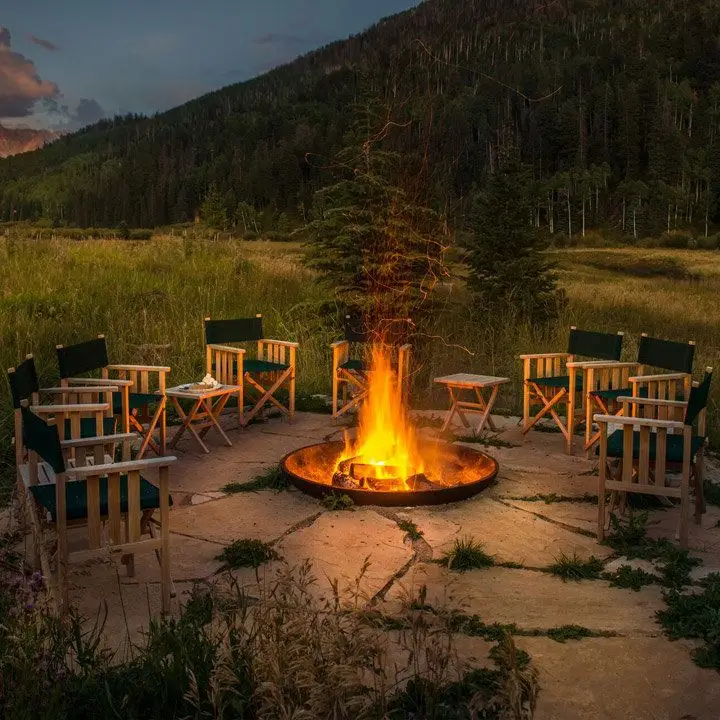 Dunton River Camp firepit with a tree-filled mountain in the background