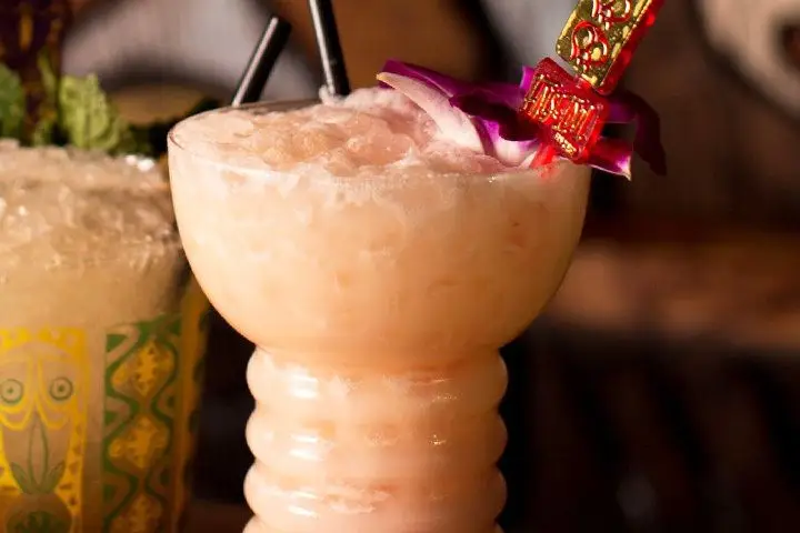 A light orange creamy cocktail served in a clear Pearl Diver Tiki glass