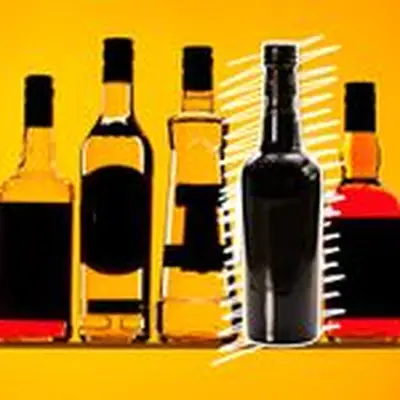 Photo illustration of various bottles with blacked-out labels against an orange background with a white scribble emphasizing a Port bottle