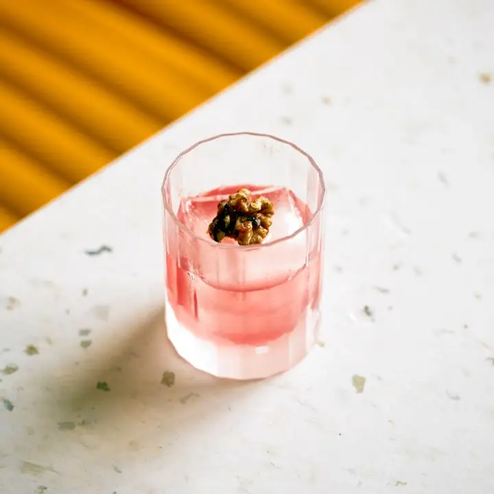 Cocktail made with scotch, black currant, cobnut, smoked rye amazake at Cub