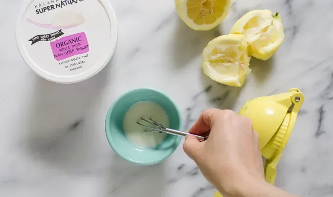 Whisking the Greek yogurt lemon juice and powered sugar together in a small bowl.' title='Easy Blueberry Greek Yogurt Scones Recipe with Lemon