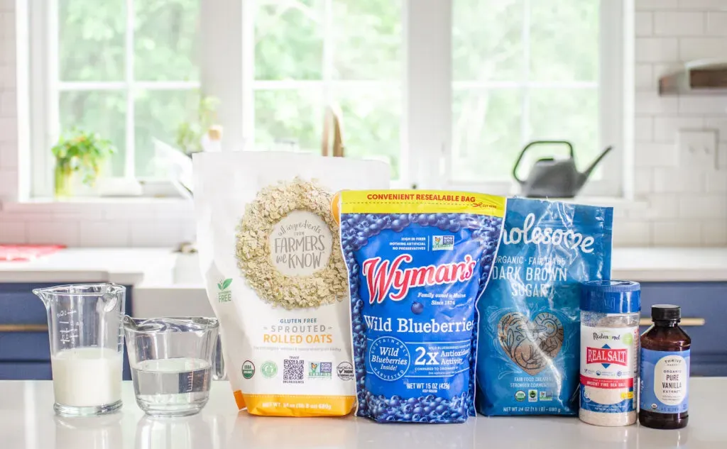 All of the ingredients needed to make blueberry oatmeal laid out on a white countertop.' title='Blueberry Oatmeal Recipe