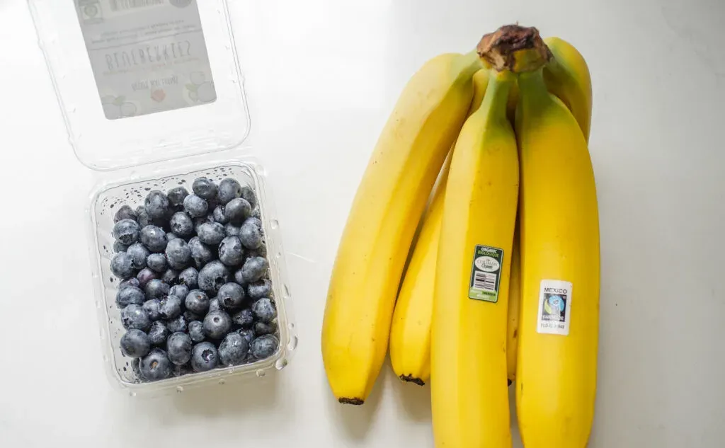 Blueberries and bananas on a white countertop.' title='Blueberry Oatmeal Recipe
