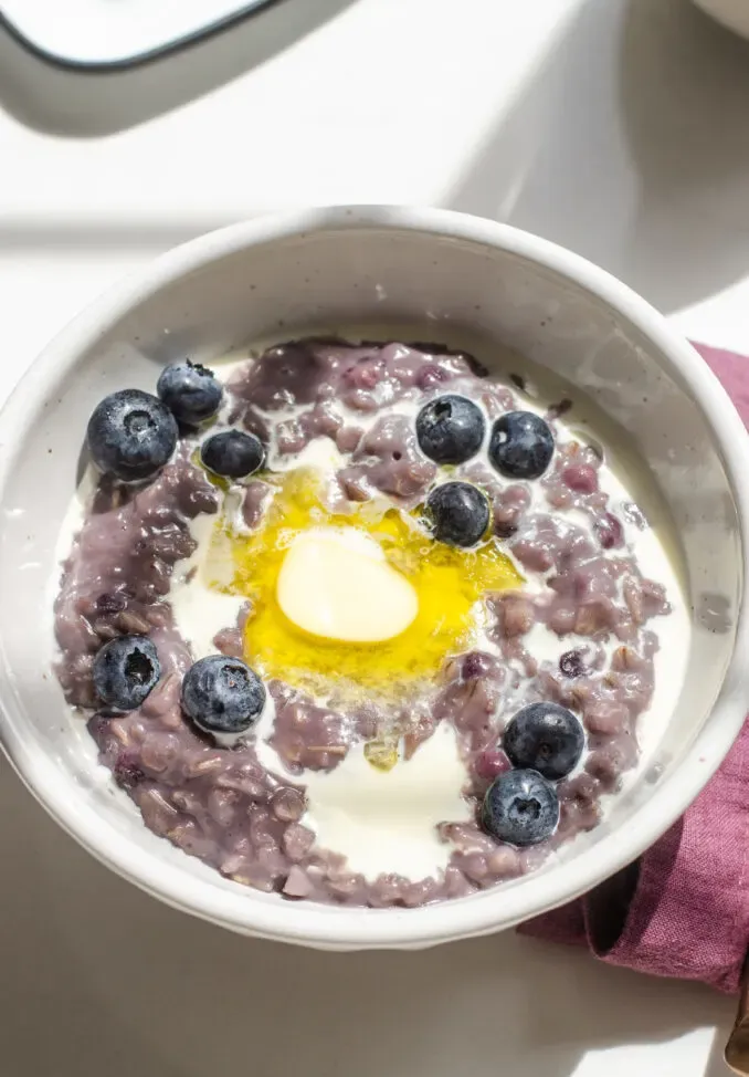 A bowl of blueberry oatmeal with cream butter and fresh blueberries on top.' title='Blueberry Oatmeal Recipe