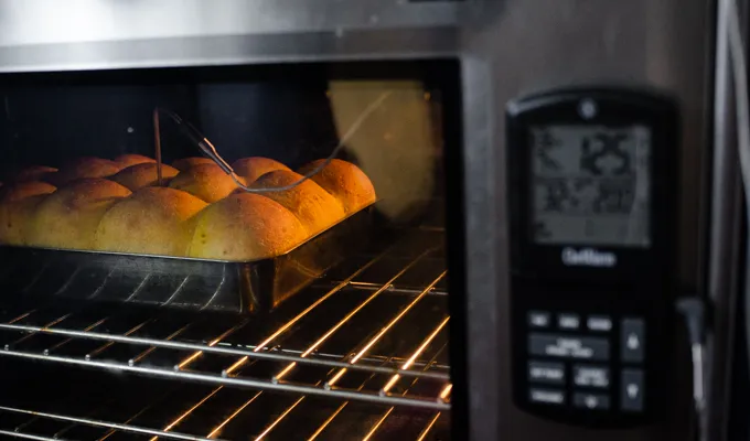 Baking the pumpkin sourdough dinner rolls with a probe thermometer.' title='Pumpkin Sourdough Dinner Rolls