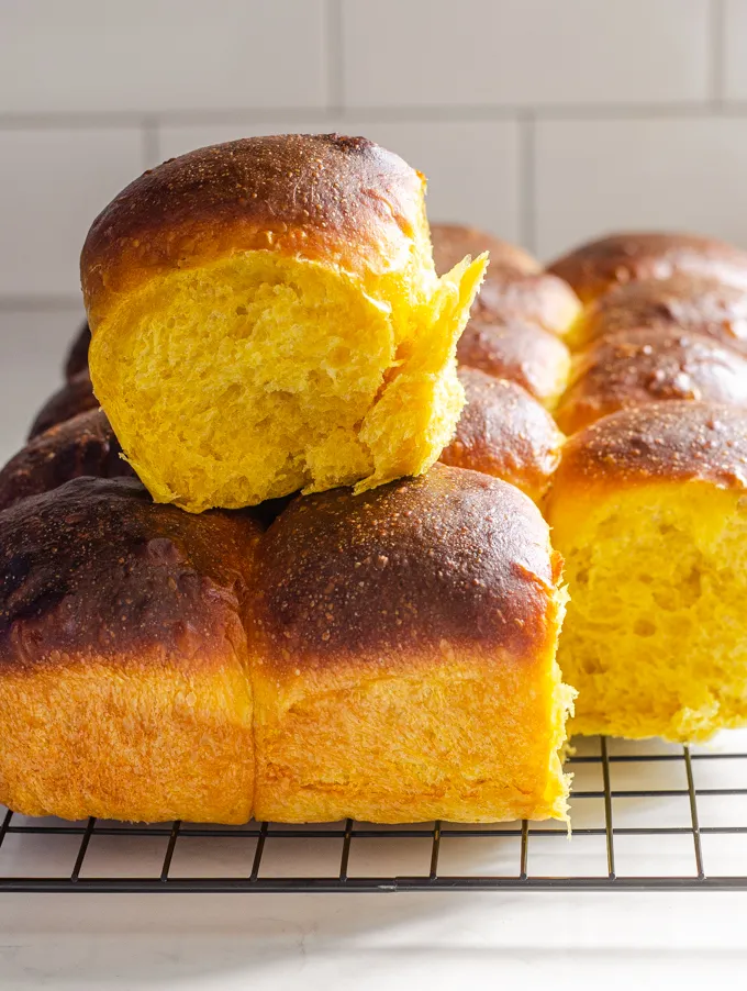 A side shot of the rolls with one of them taken away.' title='Pumpkin Sourdough Dinner Rolls