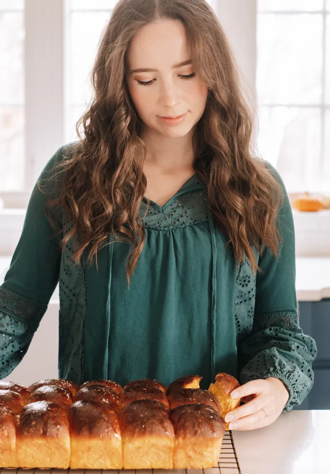 Pulling one of the rolls out from the rest.' title='Pumpkin Sourdough Dinner Rolls