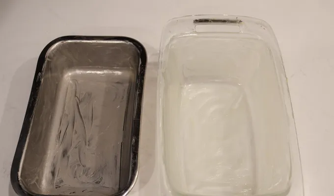 Greasing two loaf pans: one stainless steel and the other glass.' title='Sourdough Brioche