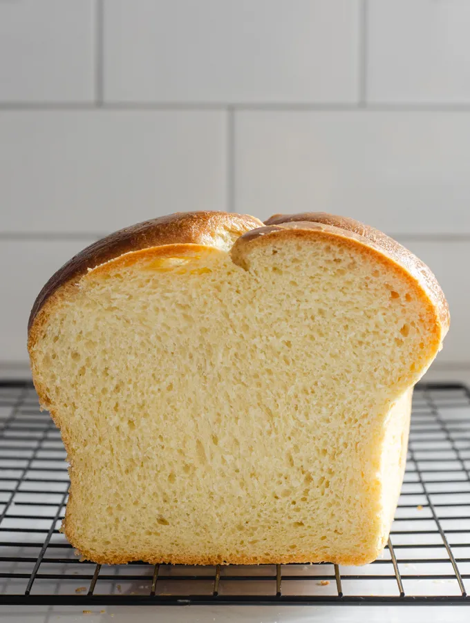 A side view of a loaf of sourdough brioche bread with a slice taken out.' title='Sourdough Brioche
