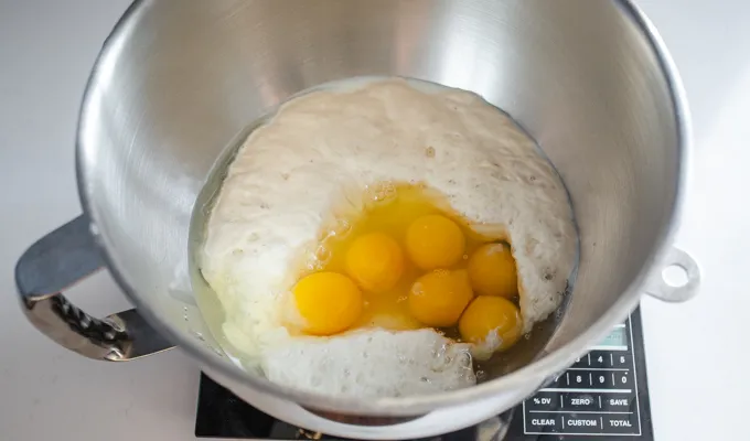 Adding the milk starter and eggs to the stand mixer bowl.' title='Sourdough Brioche