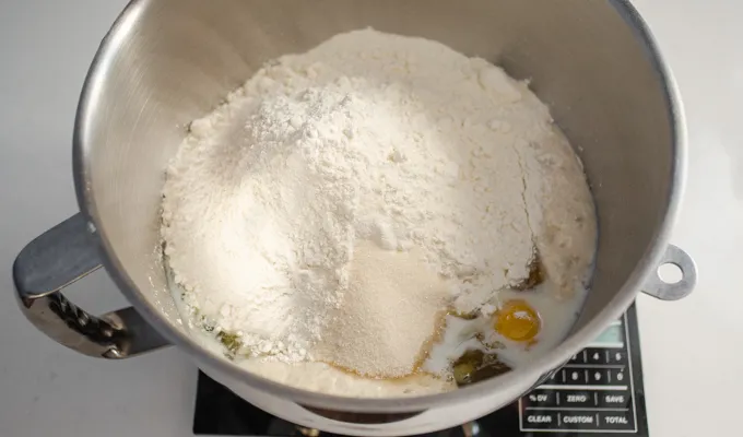 Adding the flour and sugar to the stand mixer bowl.' title='Sourdough Brioche