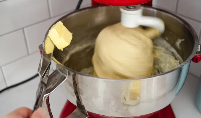 Slowly adding the butter a tablespoon at a time.' title='Sourdough Brioche