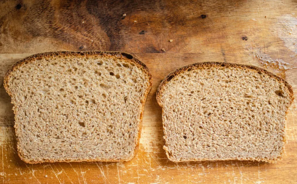 A side by side comparison of whole wheat sourdough breads. On the left is a slice of bread from a loaf risen with a white flour starter and on the right is a slice risen from a whole wheat sourdough starter. ' title='Healthy Whole Wheat Sourdough Sandwich Bread
