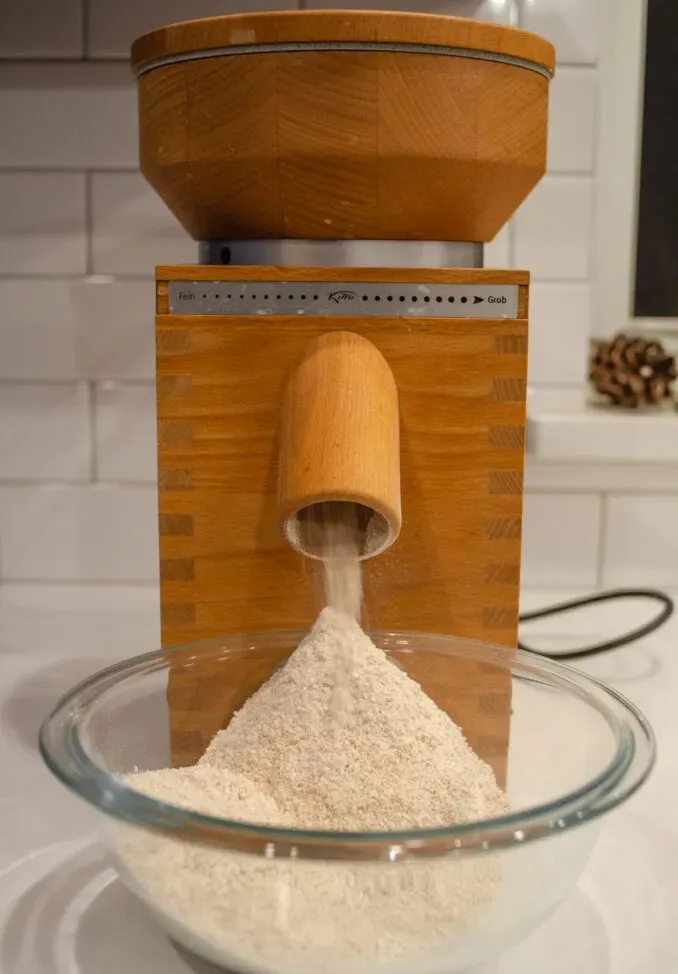 Grinding wheat berries into freshly milled whole wheat flour using th e KoMo Fidibus classic.' title='Healthy Whole Wheat Sourdough Sandwich Bread