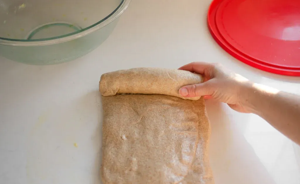 Forming the loaf of sourdough bread by rolling it up like a jellyroll. ' title='Healthy Whole Wheat Sourdough Sandwich Bread