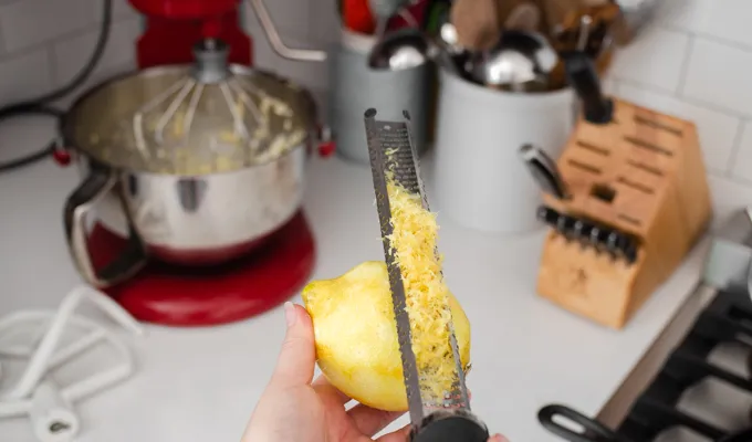 Zesting a lemon with a microplane grater.' title='Strawberry Rhubarb Crumb Cake