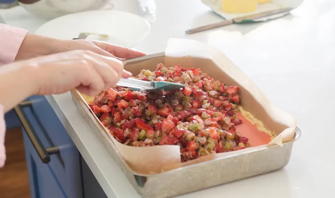 Adding the strawberry rhubarb mixture on top of the cake batter.' title='Strawberry Rhubarb Crumb Cake