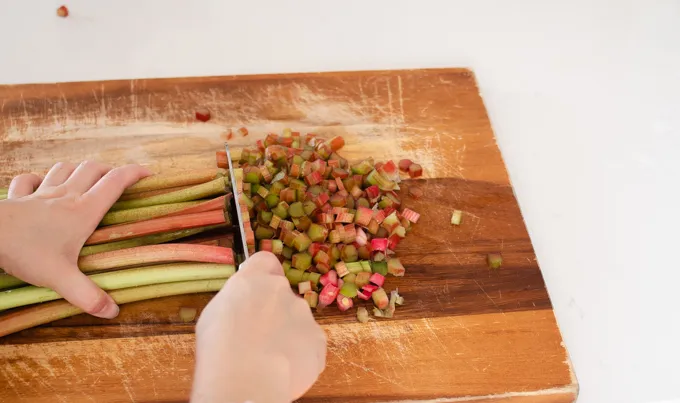 Chopping rhubarb stalks.' title='Strawberry Rhubarb Crumb Cake