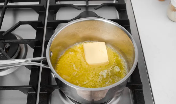Melting butter in a small-medium saucepan to make the crumble topping for the strawberry rhubarb cake.' title='Strawberry Rhubarb Crumb Cake