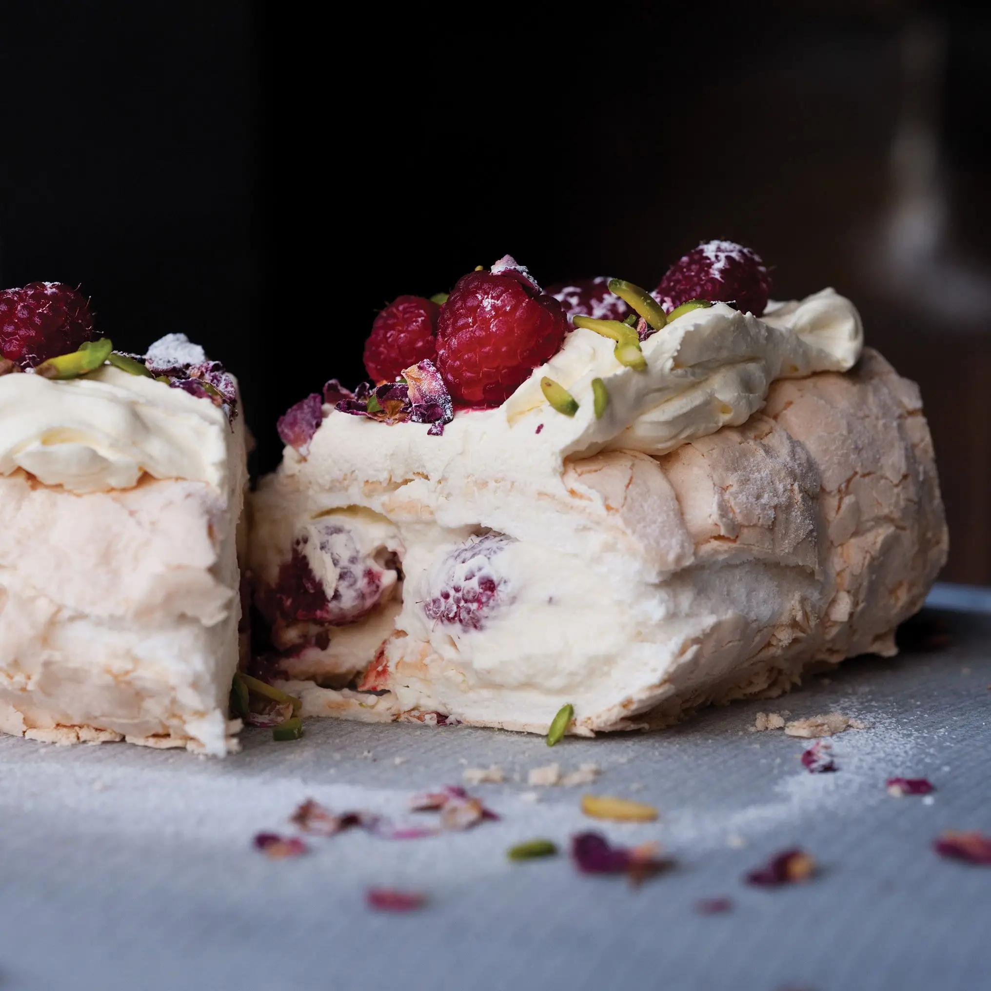 Roulade de merengue com pétalas de rosas e framboesas frescas