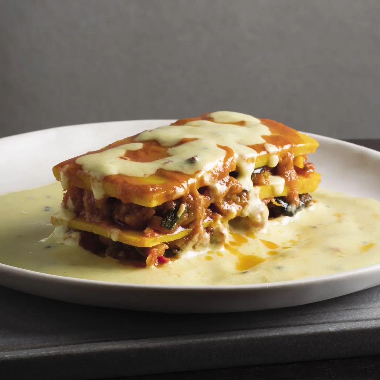 Gujarati berinjela e batata -doce 'lasanha' com molho kadi