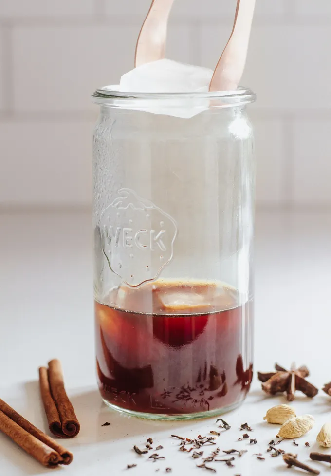 Adding ice to hot tea to make an iced chai latte.' title='Iced Chai Latte Recipe