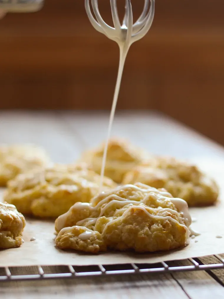 Drizzling the orange scones with the sweet glaze.' title='Orange Scones