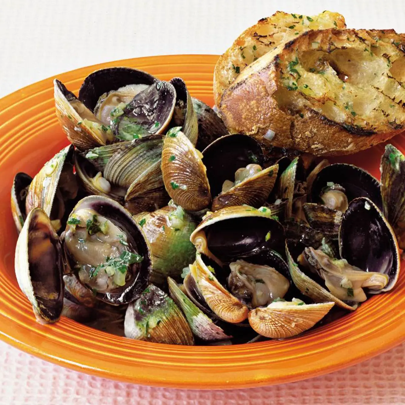 Amêijoas grelhadas com manteiga de limão e baguete grelhada