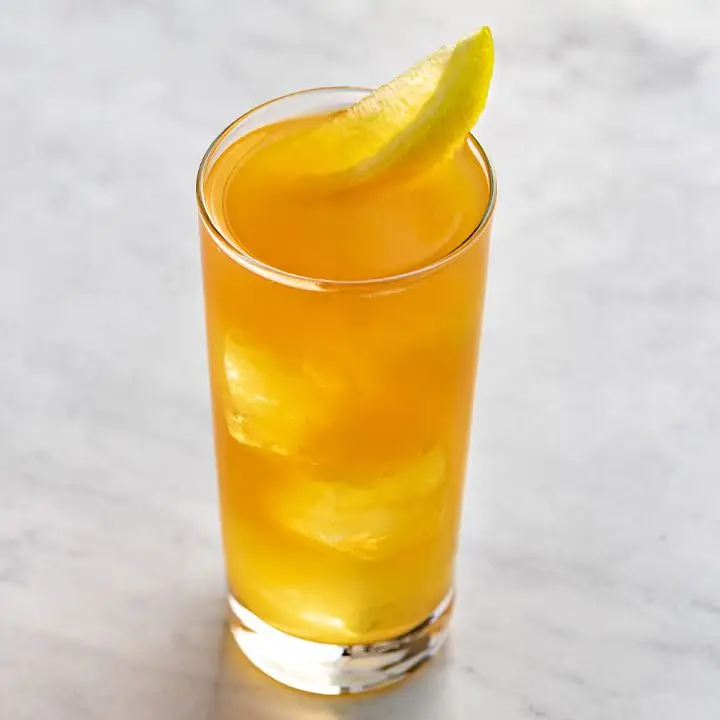 Backyard Iced Tea with lemon wedge garnish, served on white marble surface