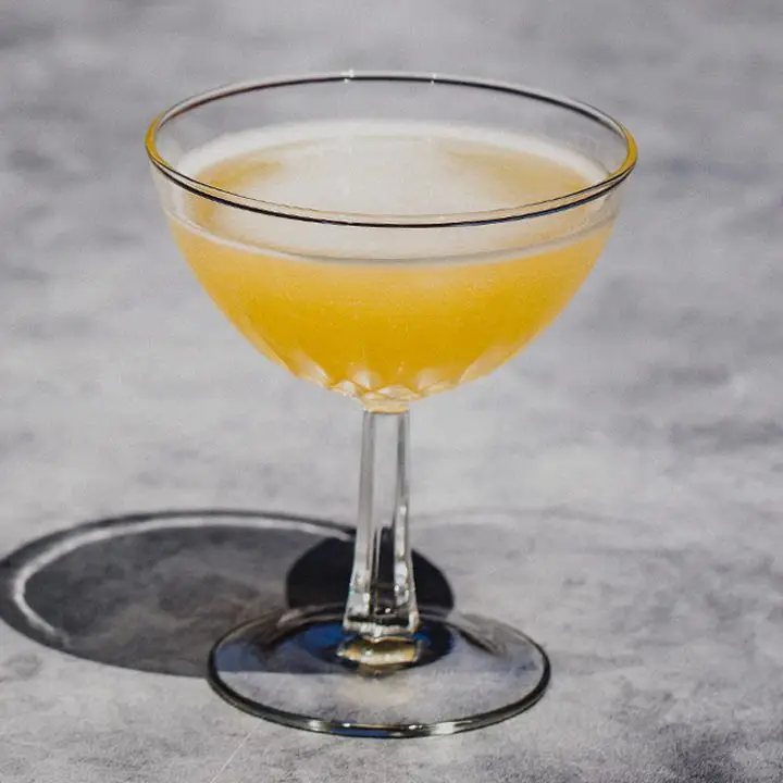 yellow-hued Queen Elizabeth cocktail in a rimmed coupe glass
