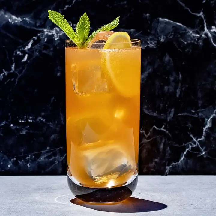 Northern Harvest Buck in a highball glass, garnished with a mint sprig and lemon wheel